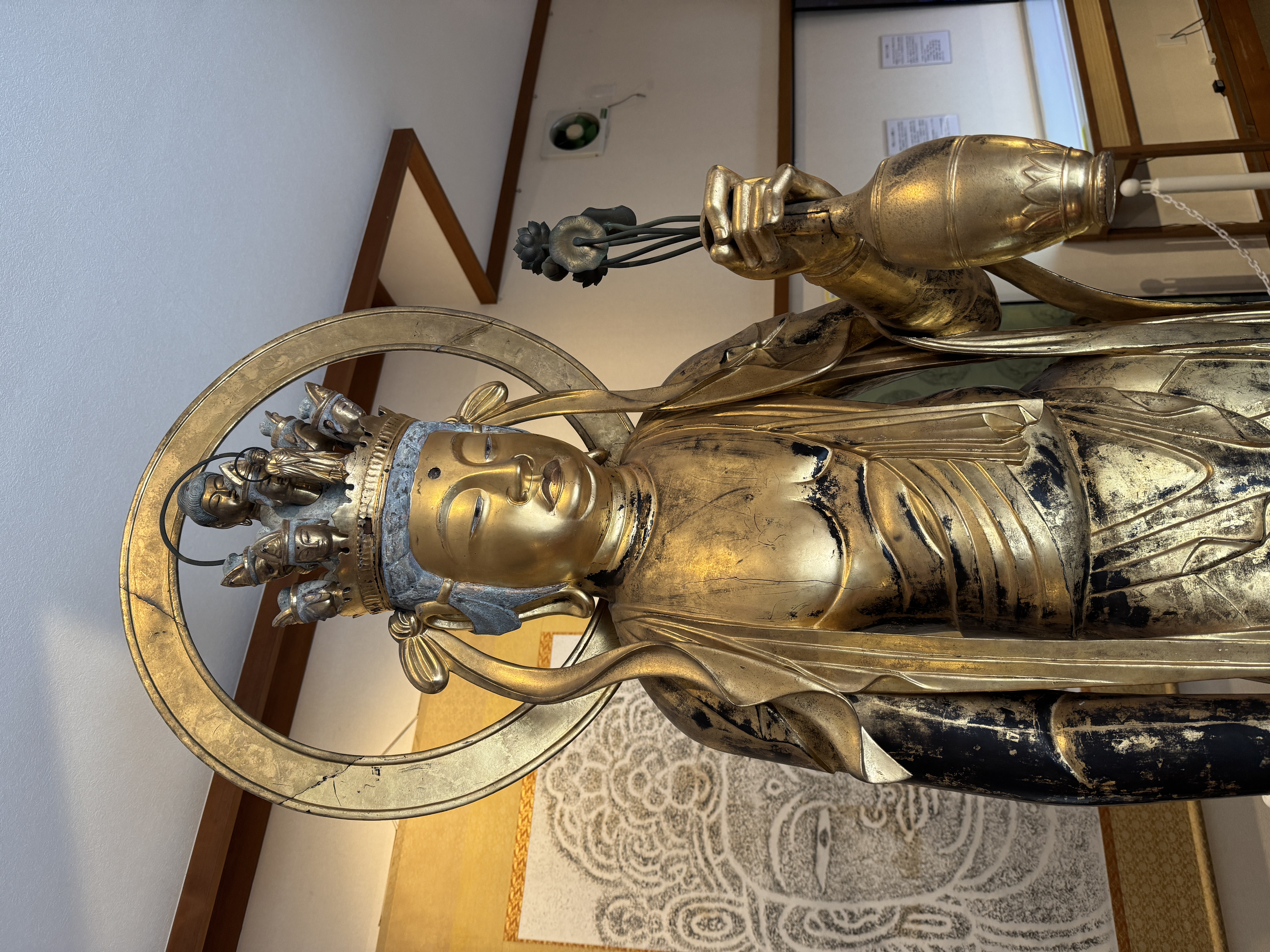 笠置寺の収蔵庫内に安置された、金色に輝く十一面観音菩薩立像。左手に水瓶を持ち、穏やかな表情で立つ美しい仏像。