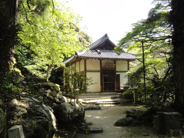 緑豊かな木々と巨石に囲まれた、笠置寺の正月堂(本堂)。落ち着いた木造建築の御堂。