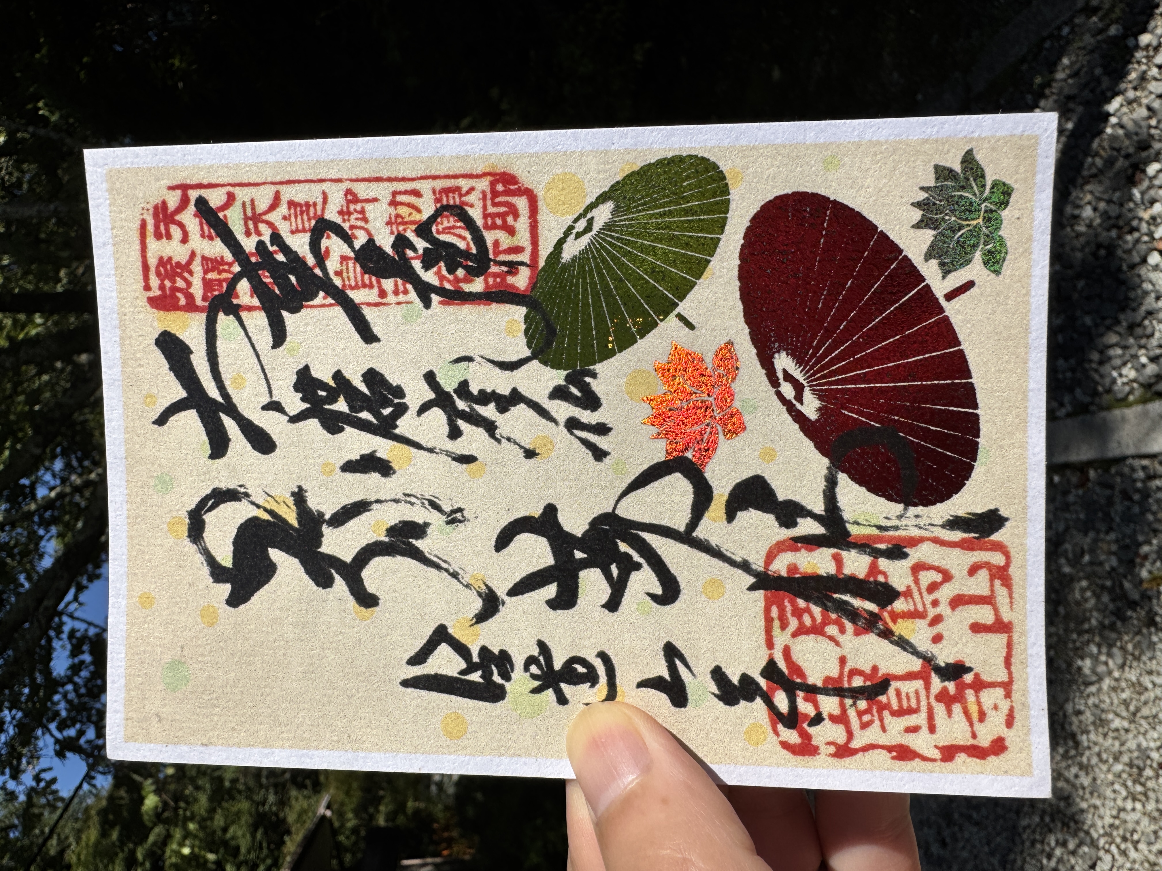 笠置寺の10月限定御朱印。淡い背景に緑と赤の和傘、そして花曼荼羅の蓮が配置されている。中央には力強い筆文字と赤い印章。